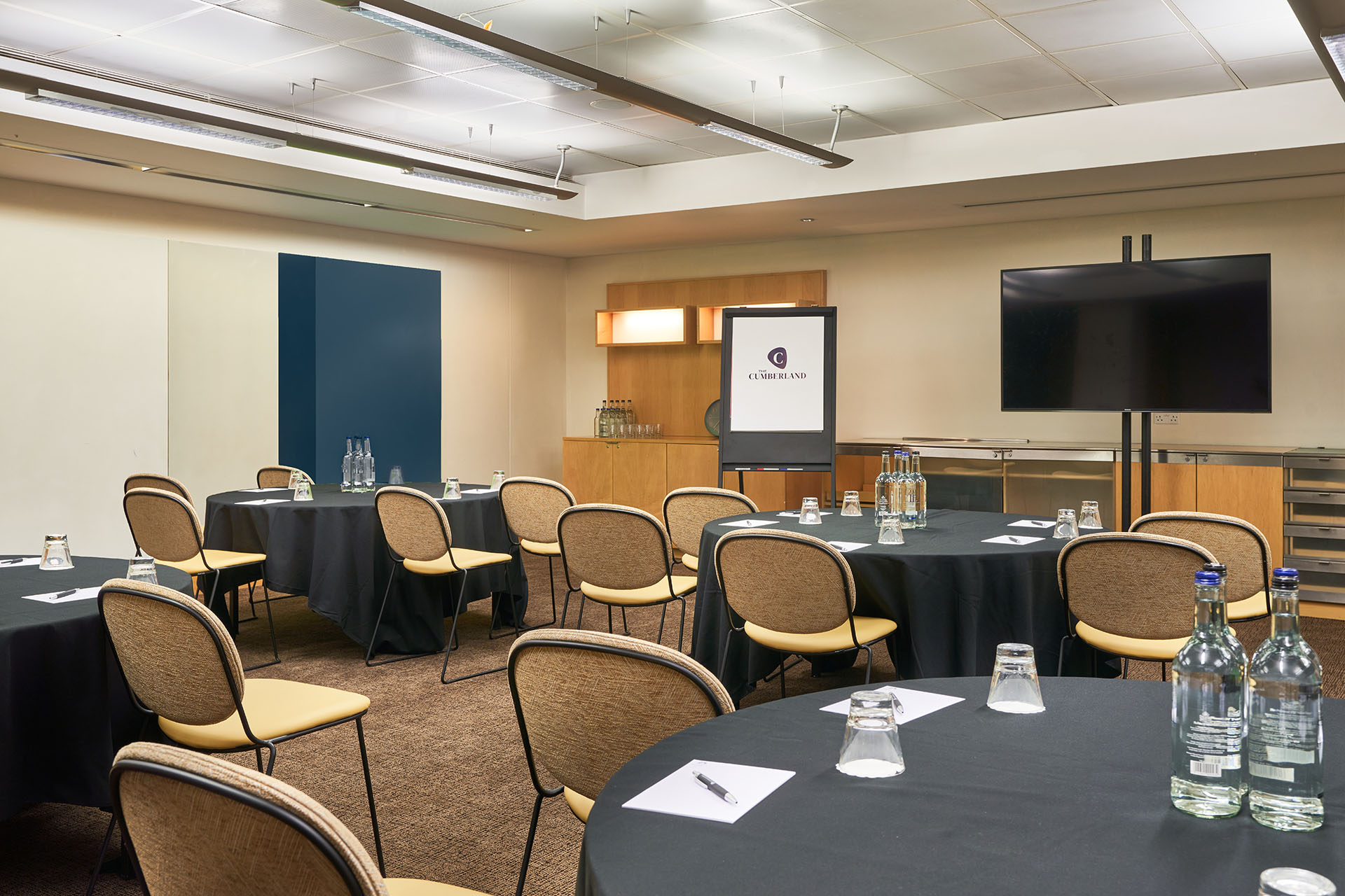 Meeting room at The Cumberland Hotel with round tables for professional events.