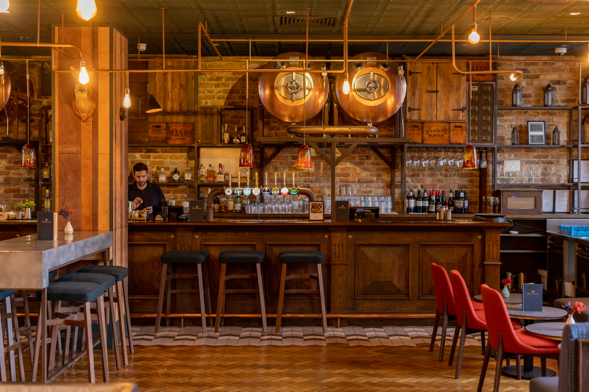 Stylish Tank Bar in Burdock with warm lighting, ideal for networking events and casual gatherings.