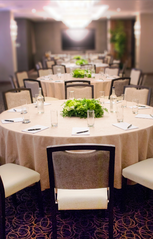 Royal London Suite meeting setup with round tables, greenery centerpieces for workshops.
