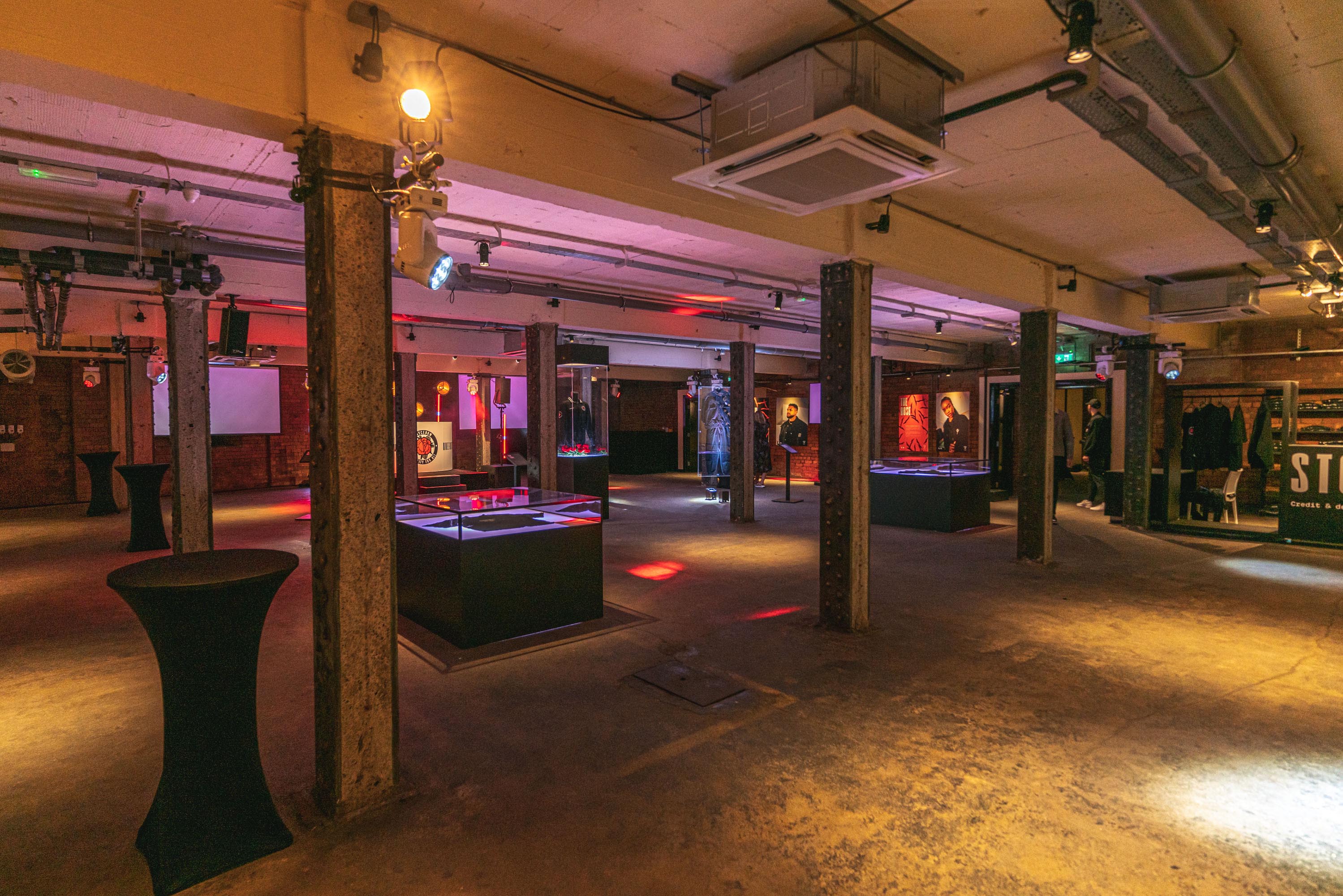 Versatile event space in Victoria Warehouse with exposed beams, ideal for networking and exhibitions.