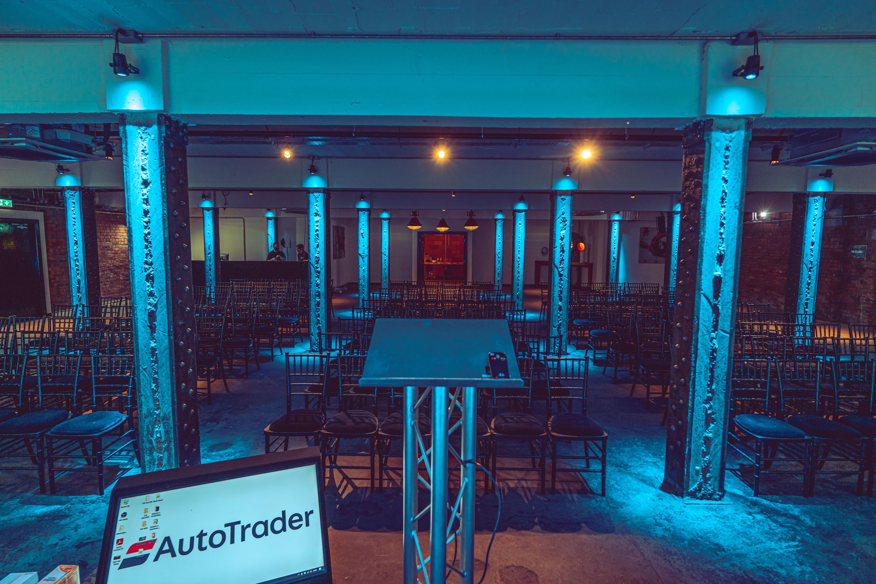 Event space at Victoria Warehouse with stage, blue lighting, ideal for conferences.
