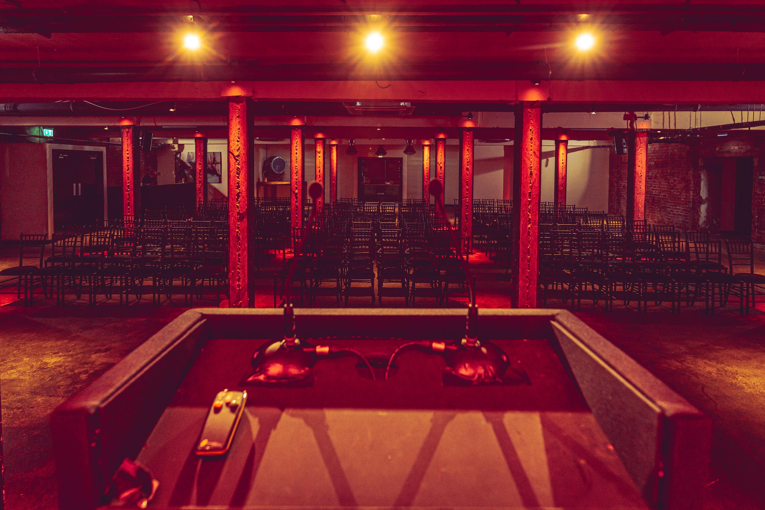 Versatile event space at Victoria Warehouse with warm lighting for presentations and performances.