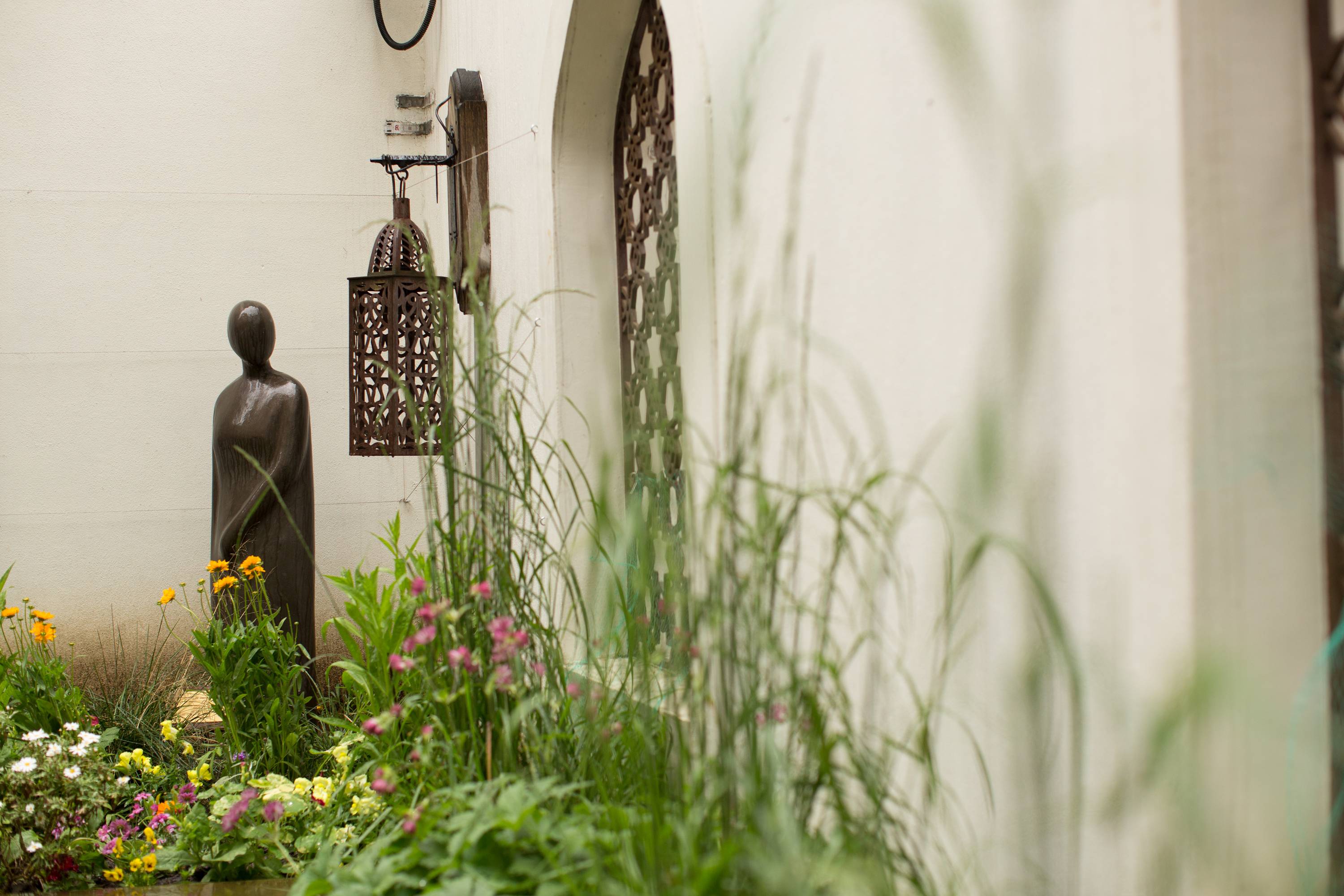 Outdoor event space at The Tent, featuring artistic statue and lush greenery.