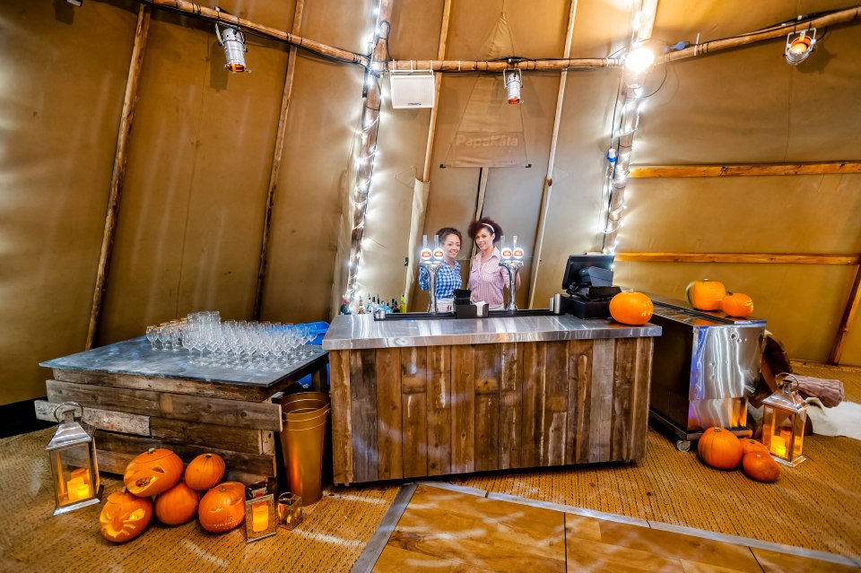 Cozy rustic event space with wooden bar, perfect for autumn gatherings and celebrations.