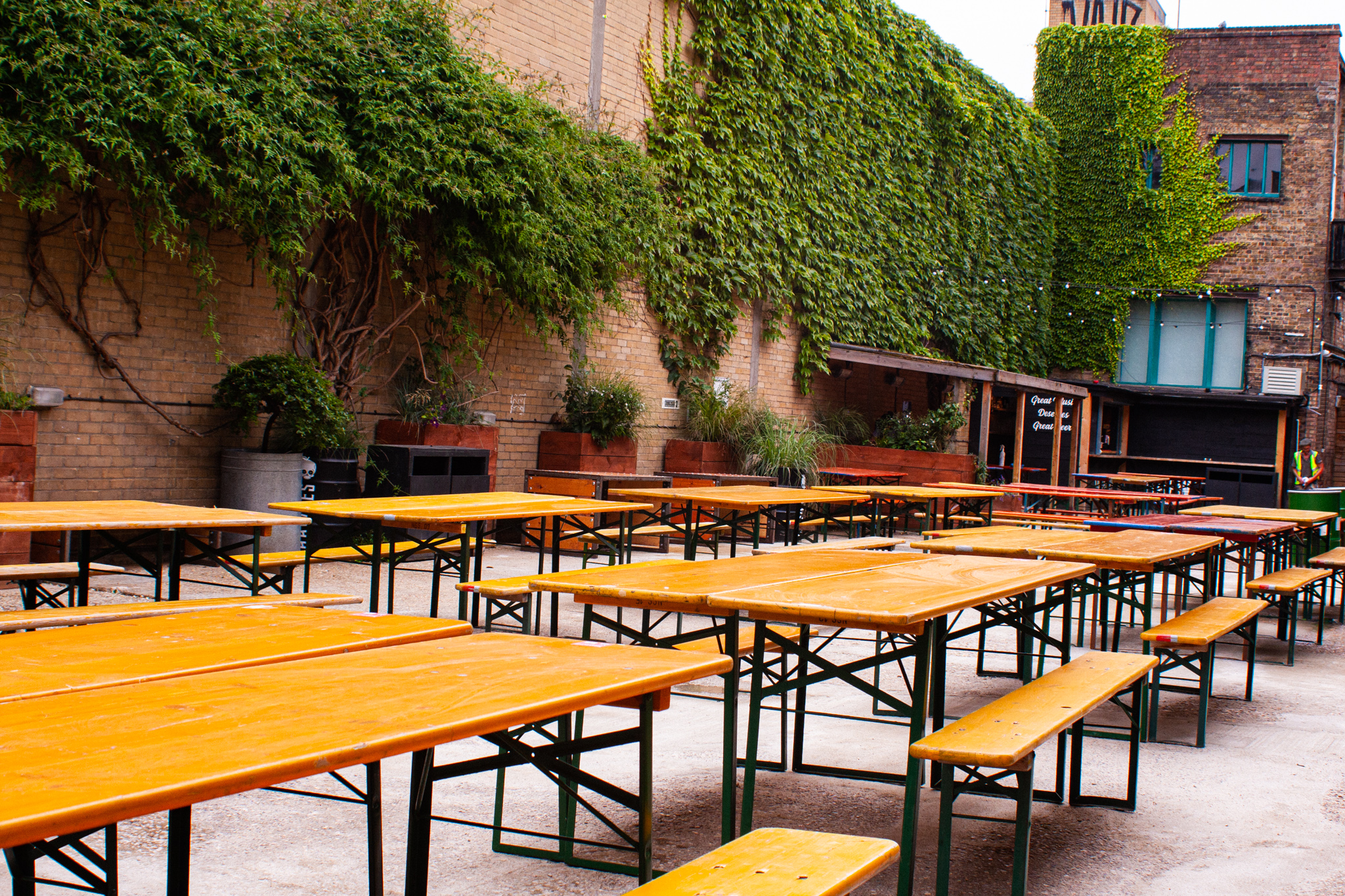 Outdoor event space with wooden tables in Strongroom Bar & Kitchen for casual gatherings.