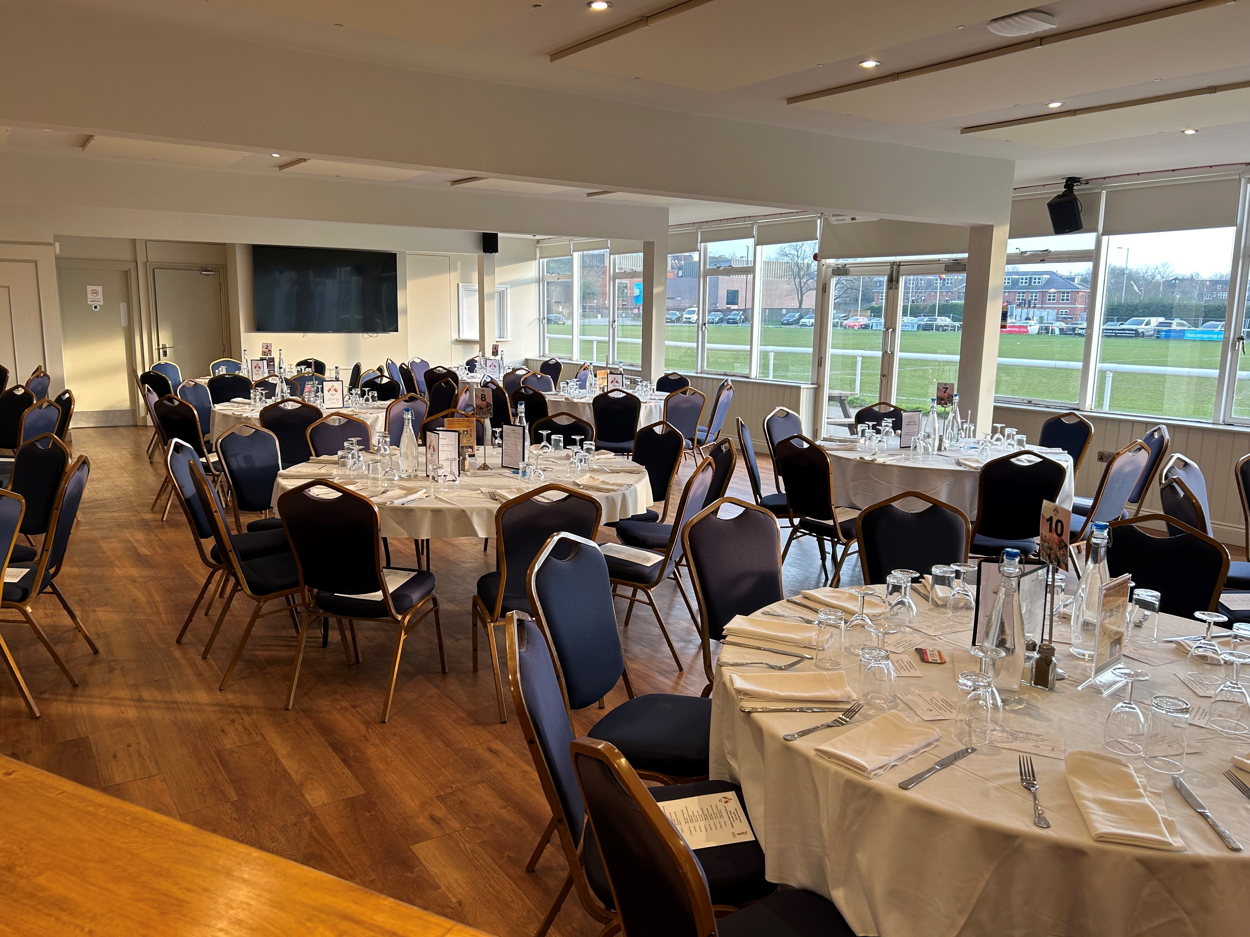 Elegant event space with round tables at Richmond Athletic Ground for banquets and gatherings.