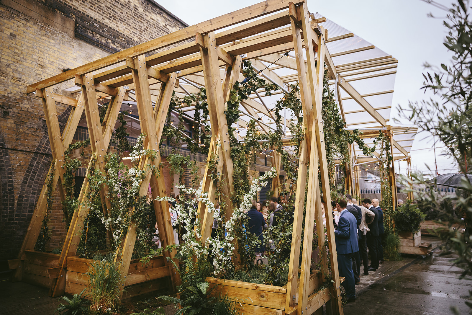 Outdoor event space at AMP Studios with wooden structure and greenery for gatherings.