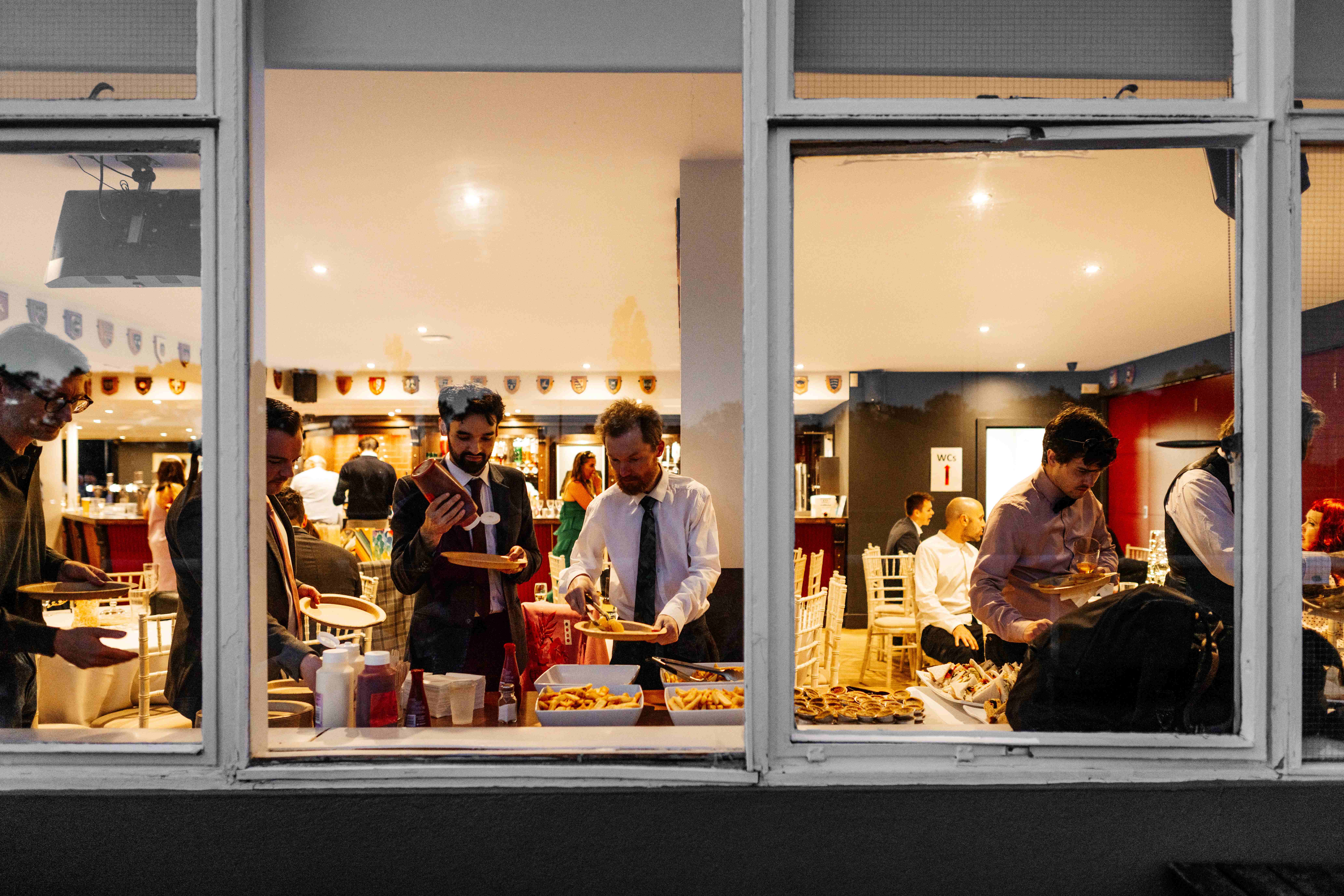 "Richmond Athletic Ground Club Room bustling networking event with refreshments and food."