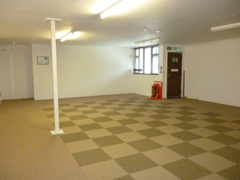 Spacious empty meeting room with checkered carpet at Deanwood Barn Conference Centre.