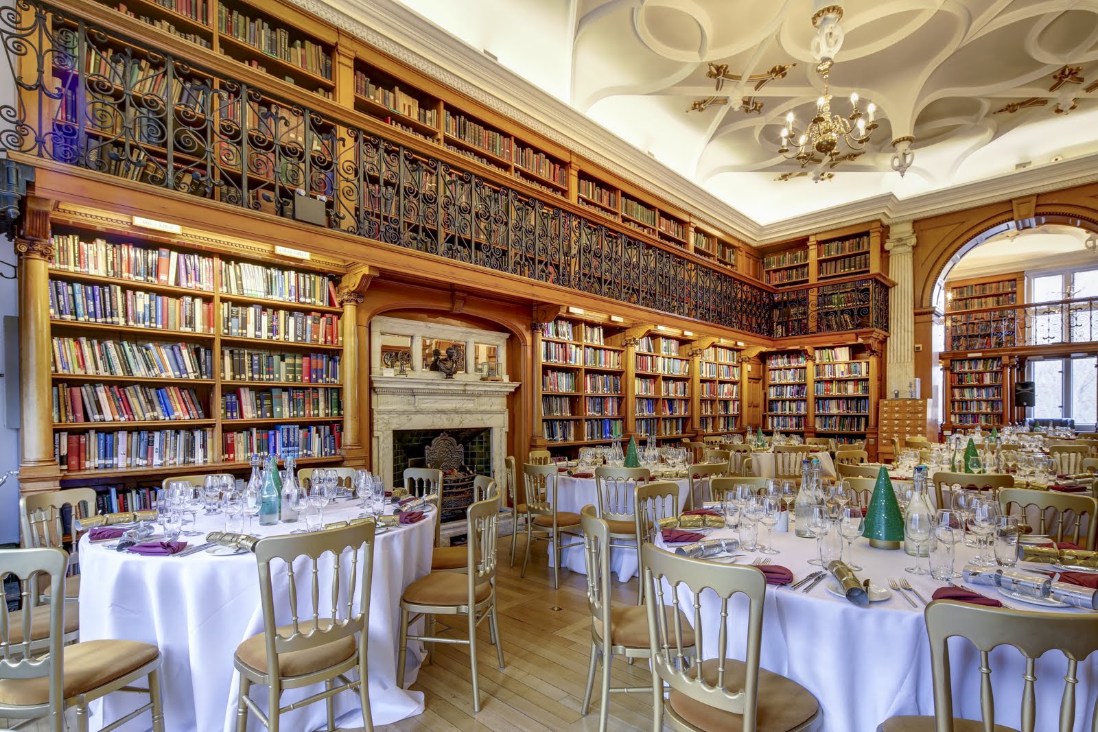 Elegant library event space with round tables, ideal for corporate gatherings and celebrations.