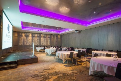 Modern event space with round tables and purple lighting at Doubletree Kingston.
