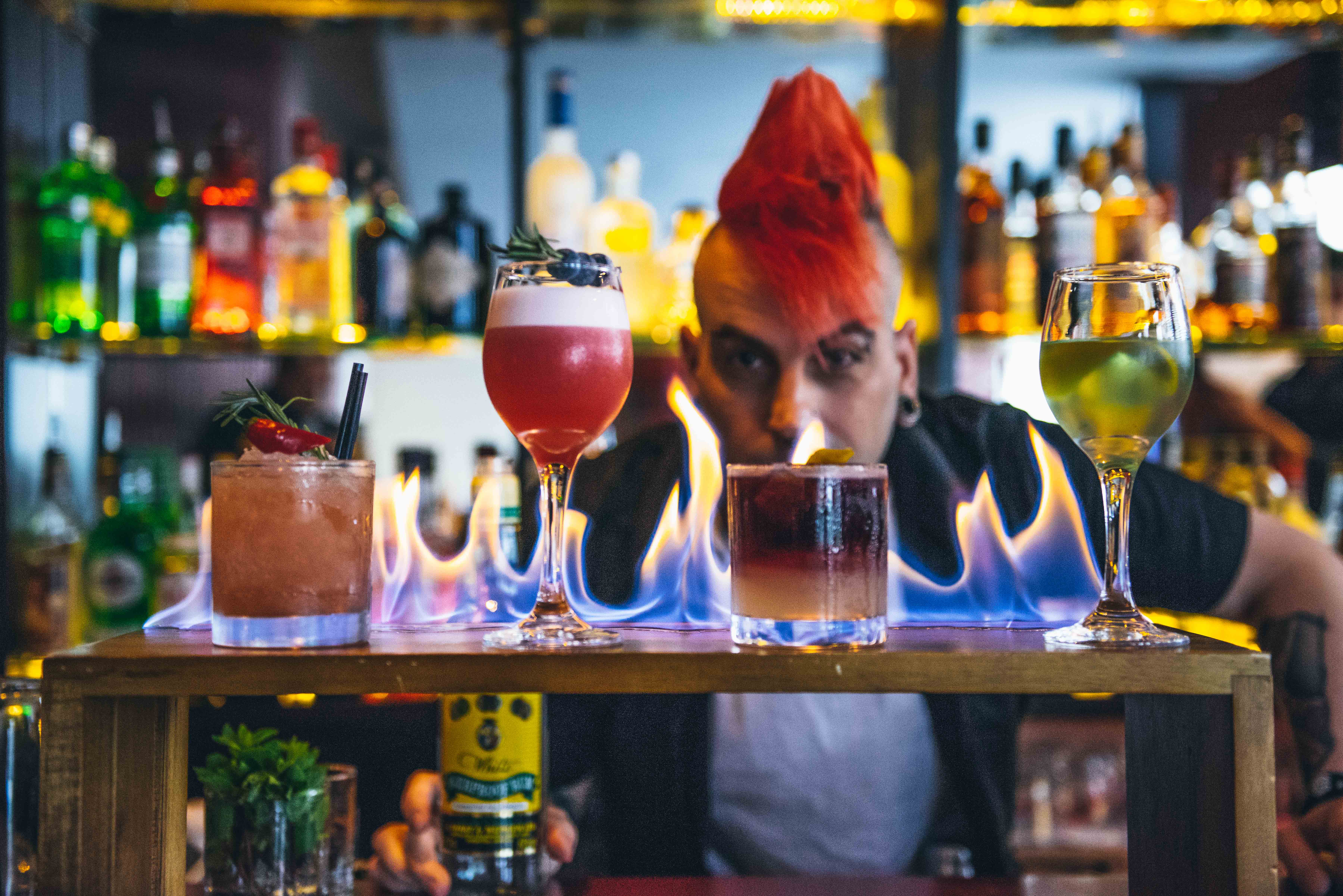 Vibrant bar at Wild Heart with flaming cocktail, ideal for events and unique drinks.