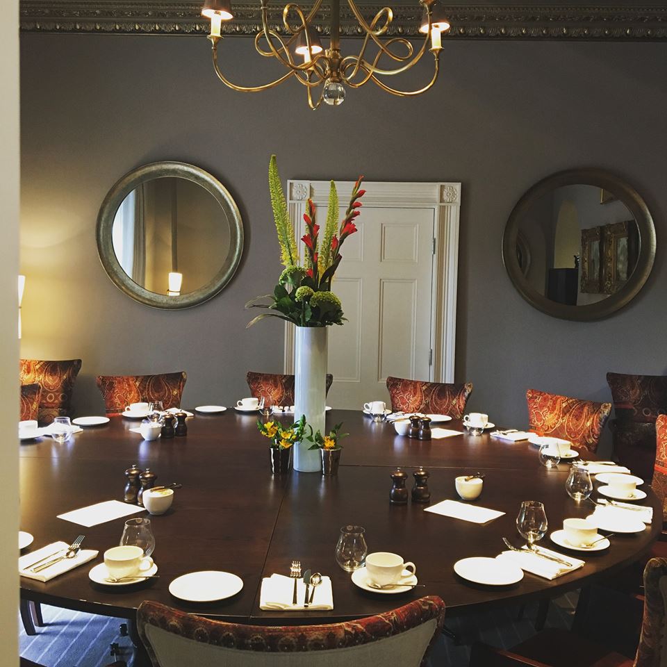 Elegant meeting room with round table, fine china for exclusive events at De Lys Room.
