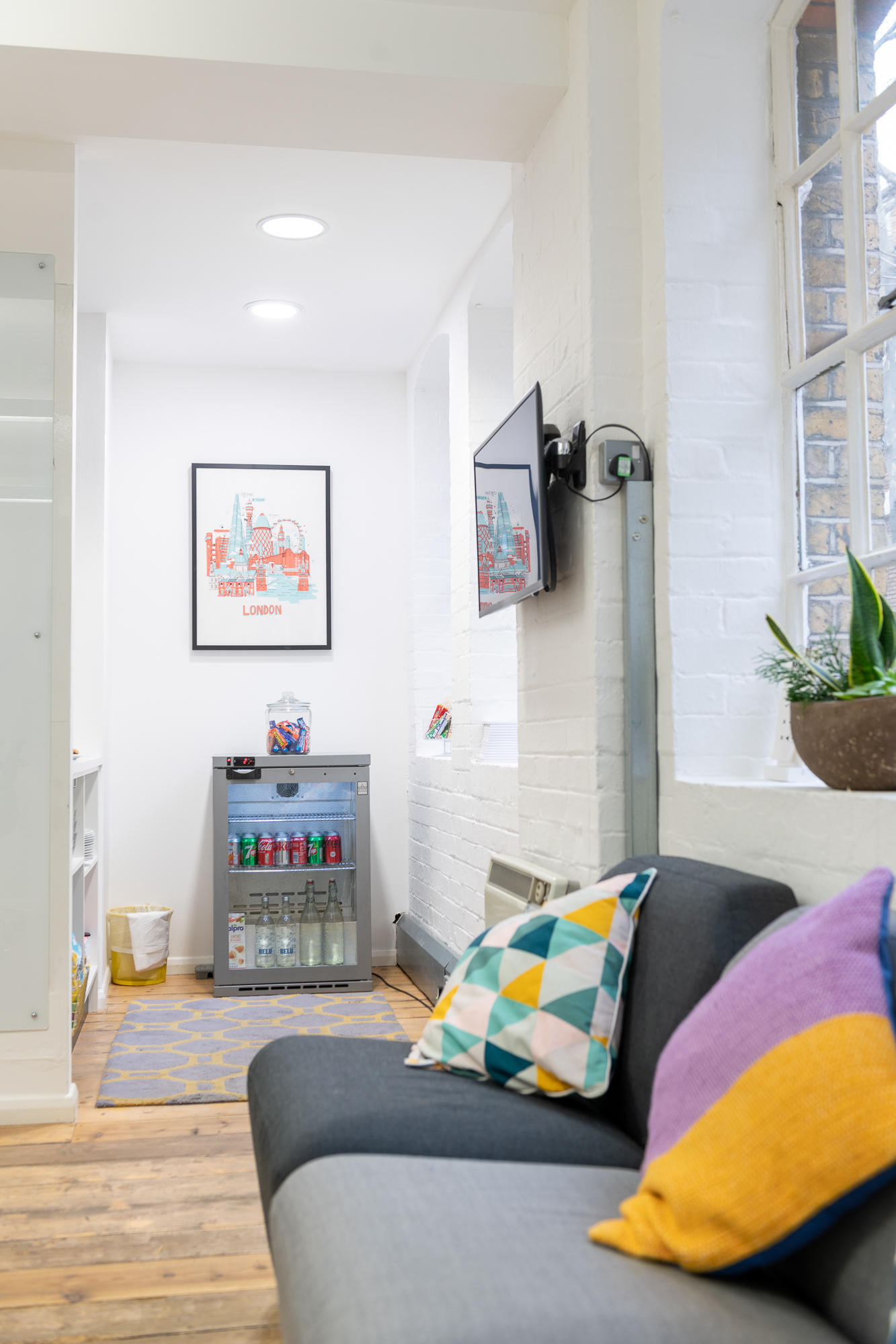 Sutherland Labs Lounge with sleek fridge, vibrant decor for events and meetings.