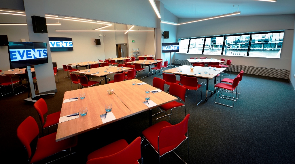 Versatile meeting space with red chairs at Imperial War Museum North for corporate events.