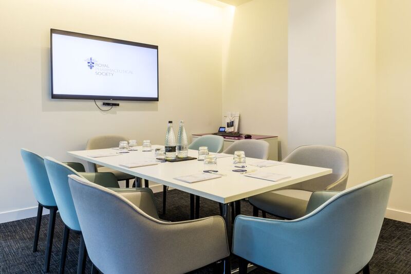 Modern meeting room at The Royal Pharmaceutical Society with sleek table and presentation screen.