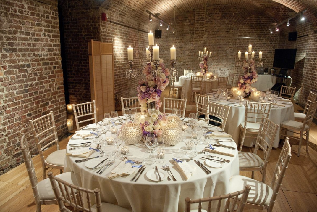 Elegant wedding banquet at RSA House with round tables and rustic brick walls.