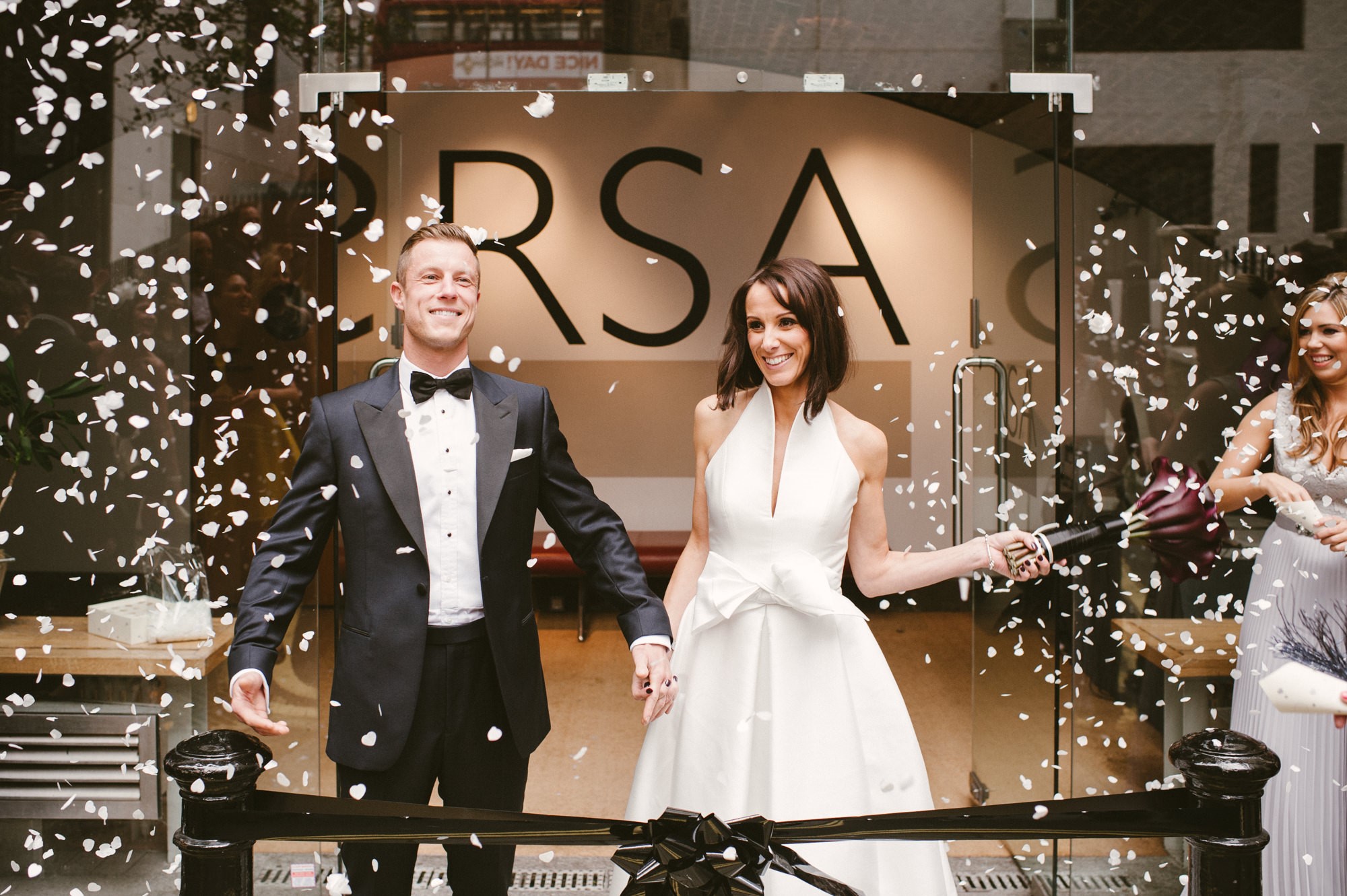 Wedding celebration at RSA House with confetti, showcasing joyful couple entrance.