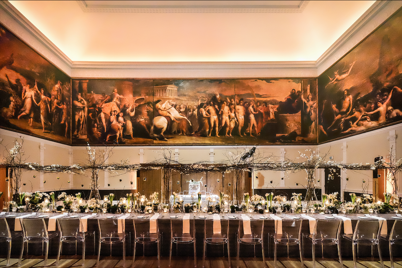 Elegant banquet hall at RSA House for weddings with floral decor and dramatic mural.