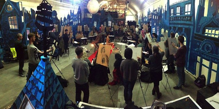 Life drawing session in vibrant event space with artists sketching together.