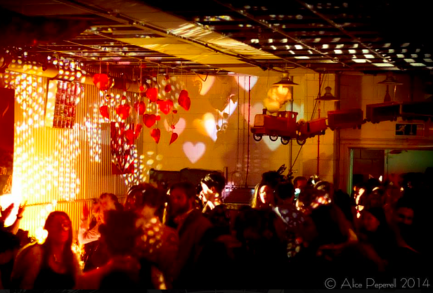 Vibrant event space with heart-shaped projections for lively celebrations and networking.