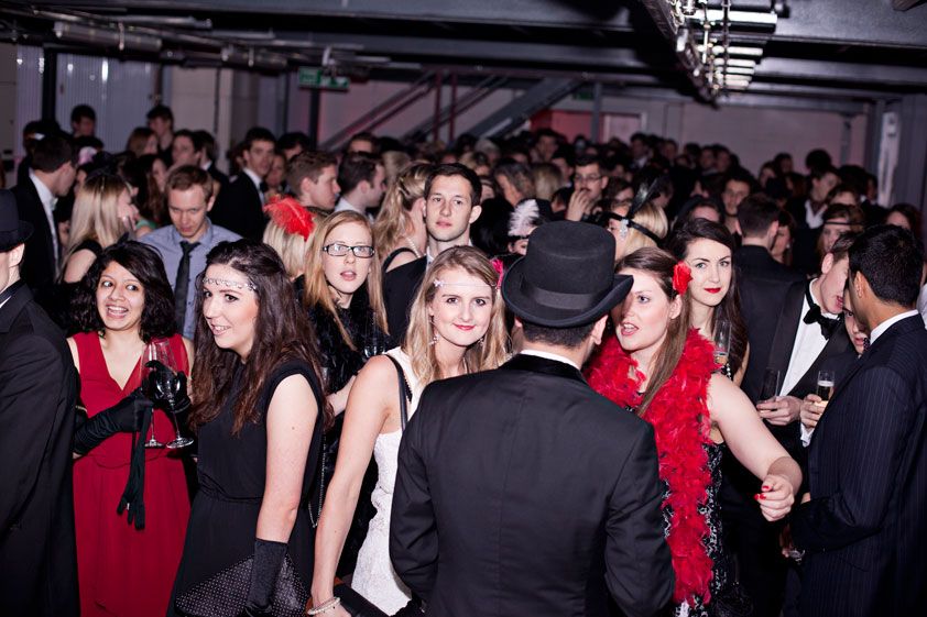 Vibrant networking event at The Vaults with attendees in formal attire and themed decor.