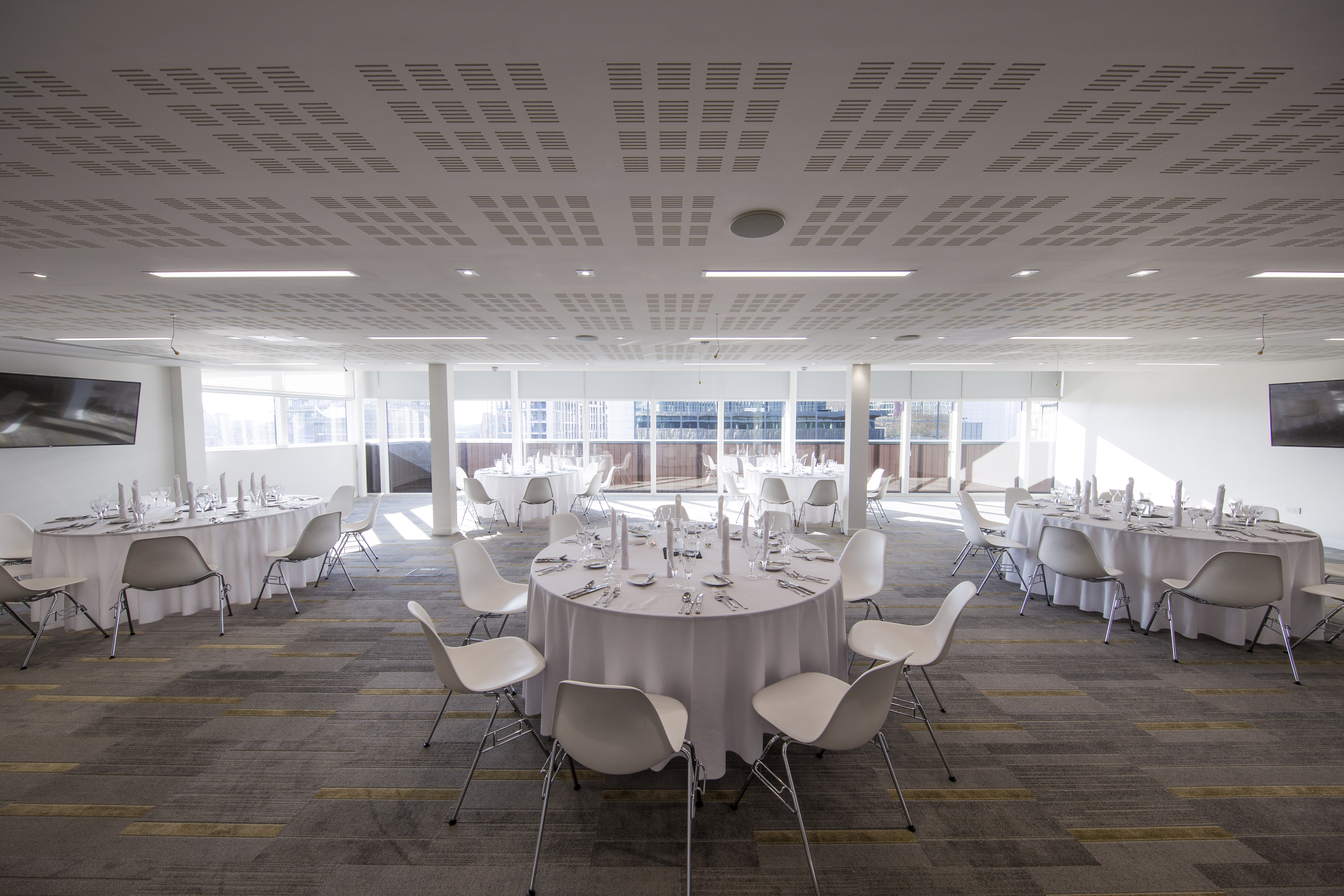 Modern event space with round tables, ideal for corporate gatherings and networking.