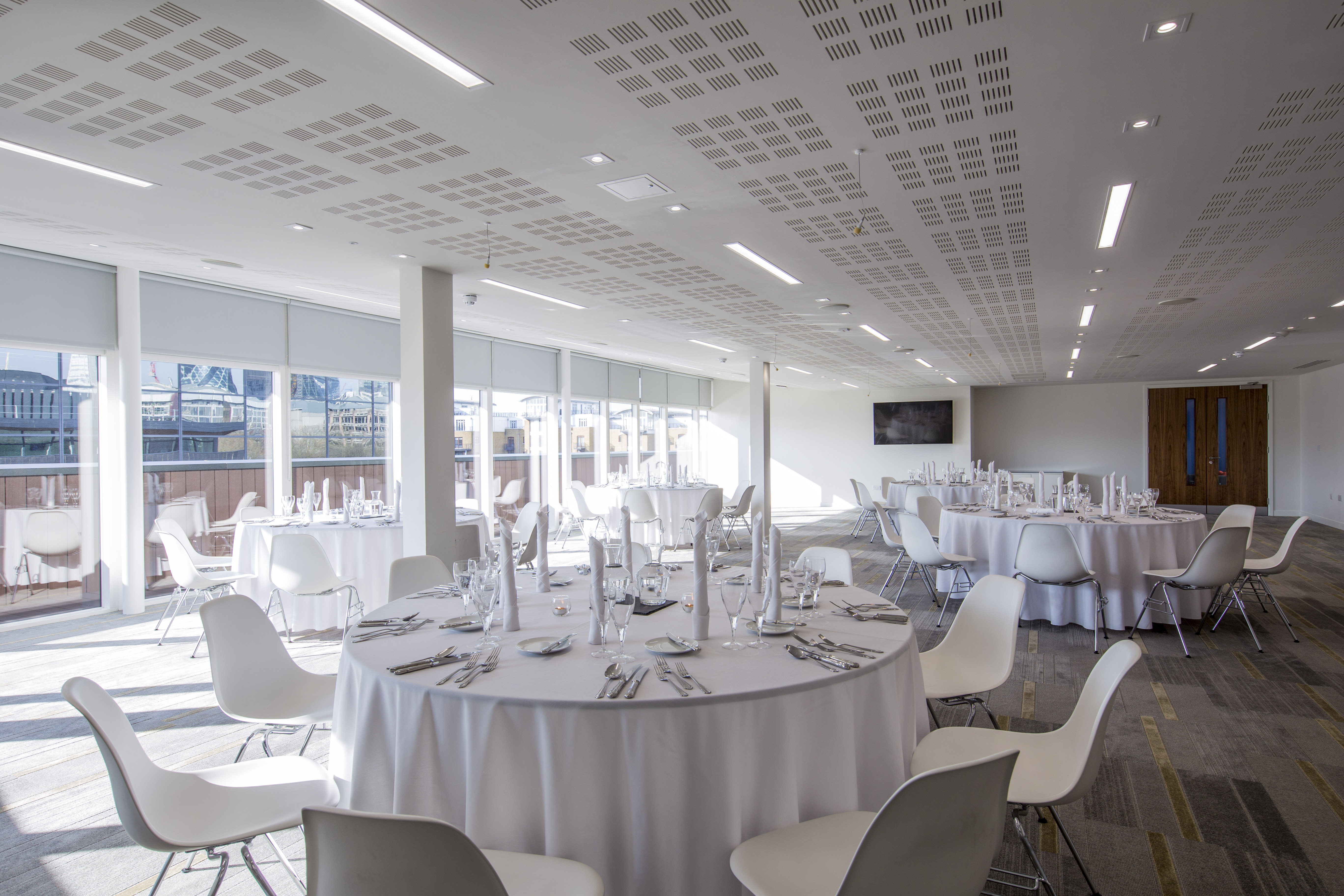 Modern event space with round tables, ideal for meetings and social gatherings.