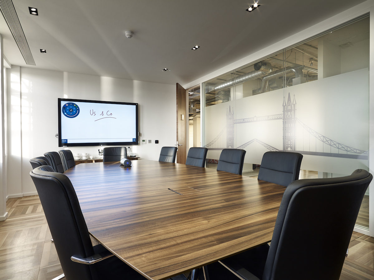 Modern conference room with wooden table, ideal for meetings and presentations.
