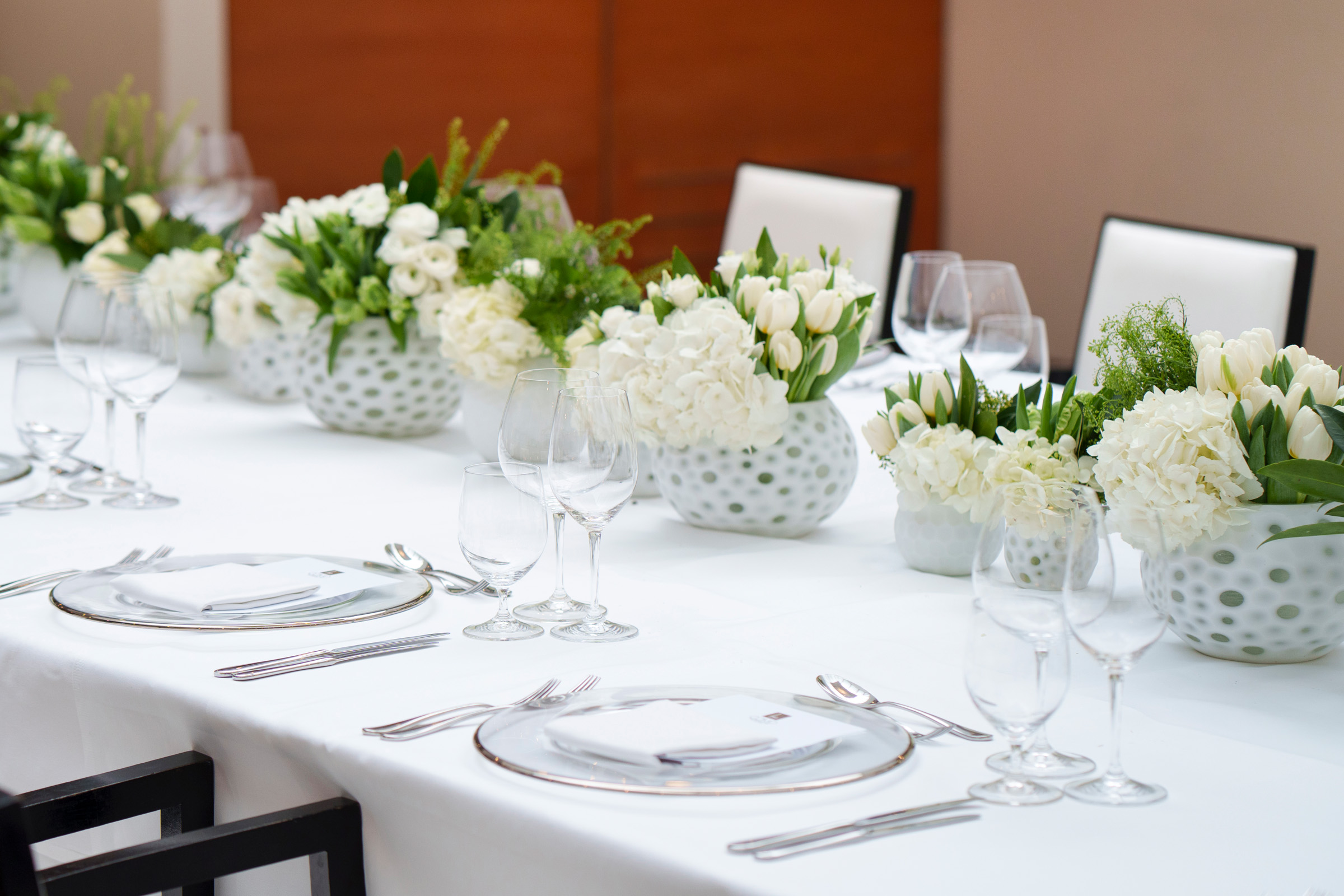 Elegant dining table in COMO Metropolitan London, featuring white floral centerpieces.