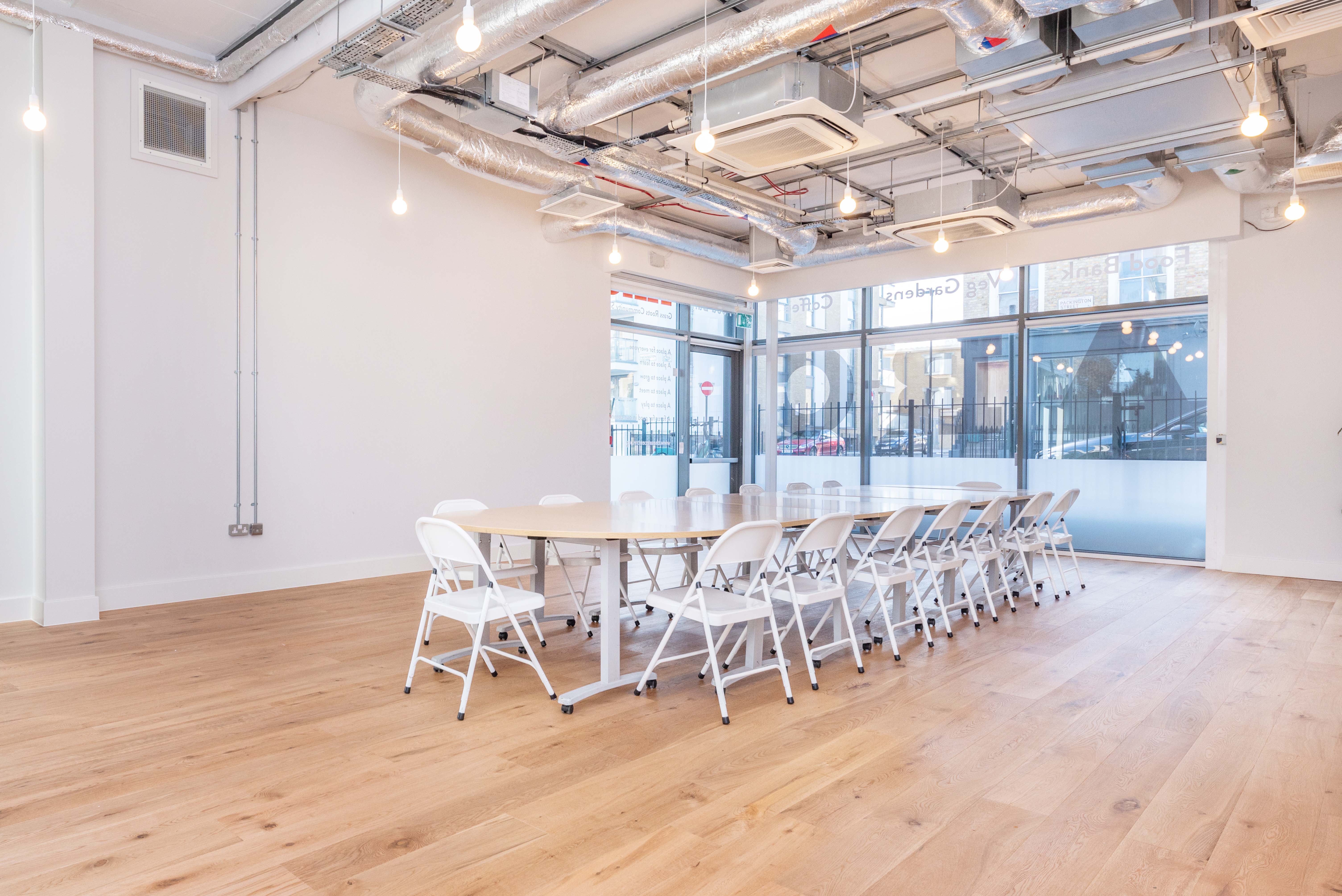 Versatile meeting room with large table and natural light, ideal for workshops in Islington.
