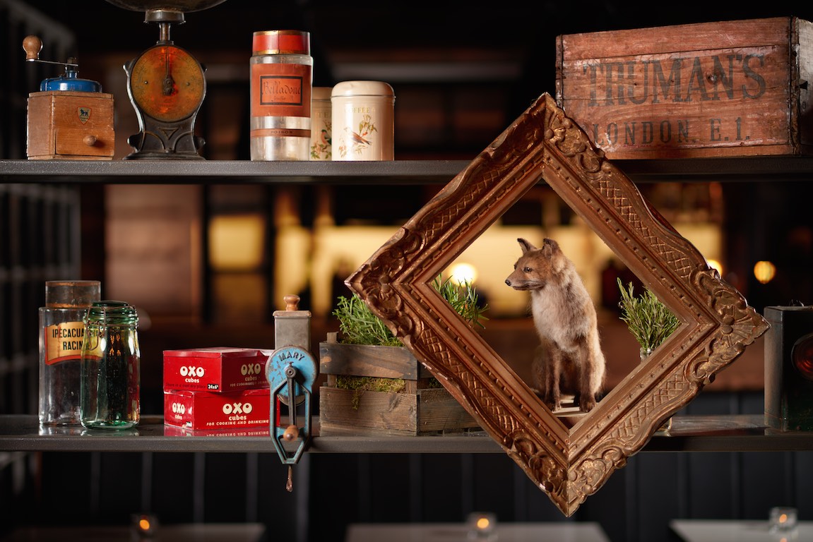 "OXBO Restaurant vintage decor with framed fox, perfect for unique event ambiance."