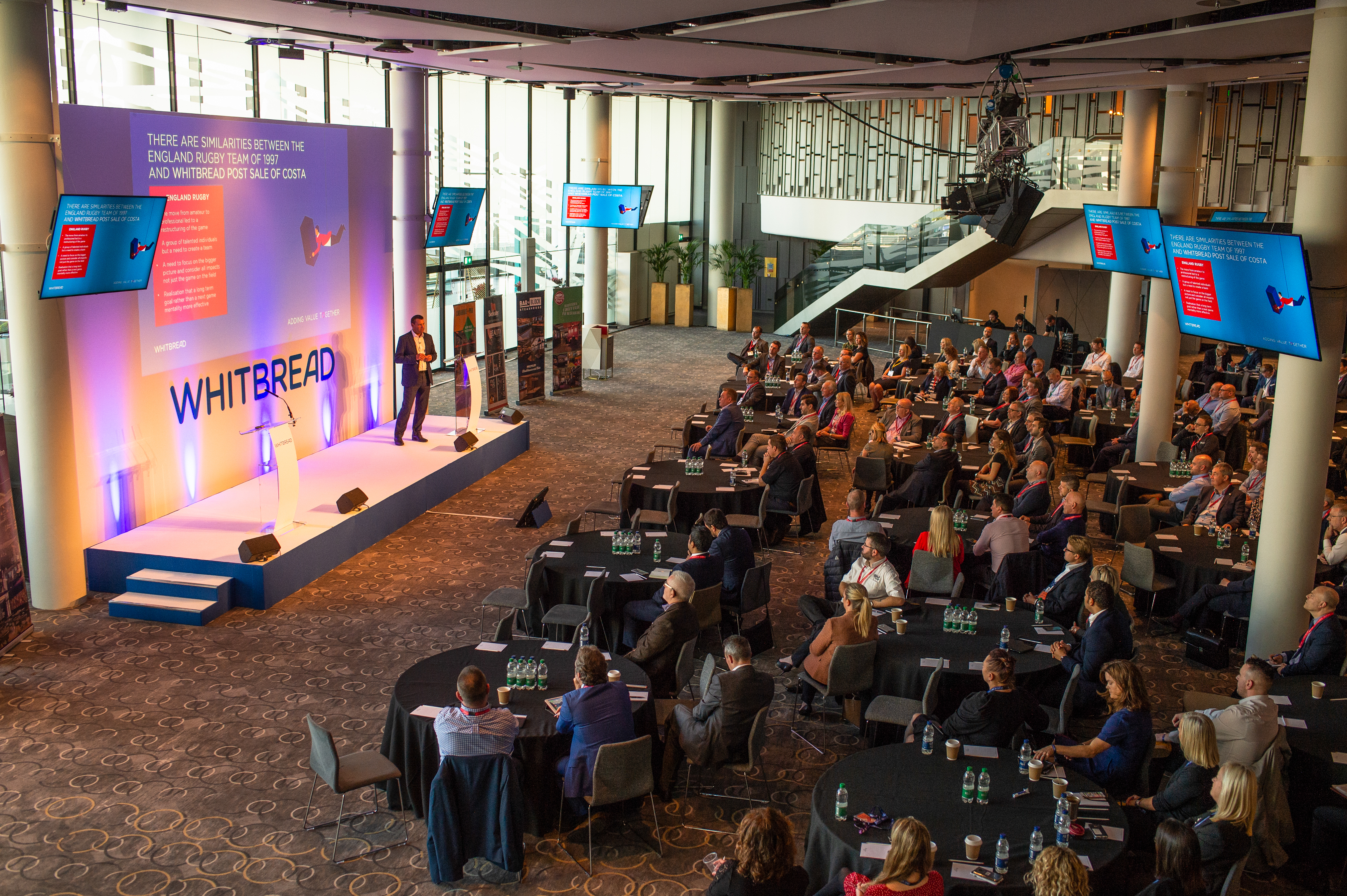 Bobby Moore Room at Wembley Stadium, modern conference setup with engaged audience.