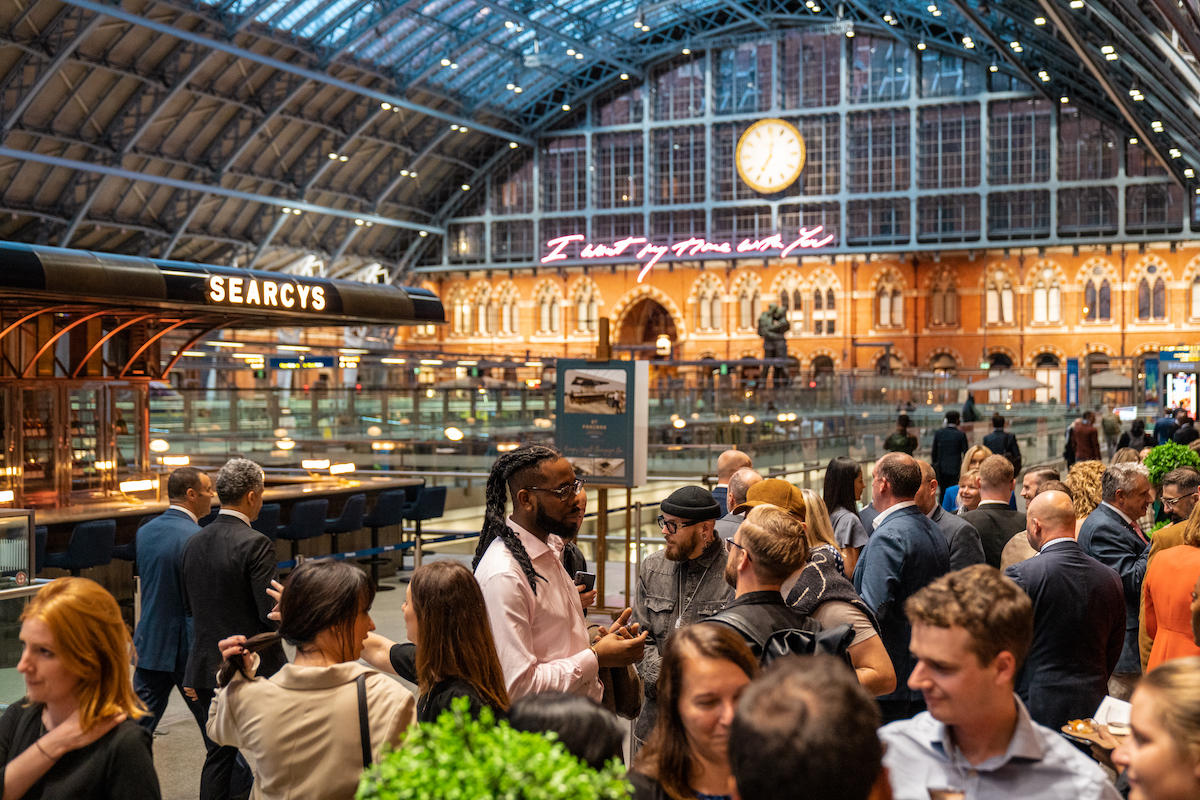 Vibrant networking event at St Pancras Champagne Bar with arched ceiling and catering.