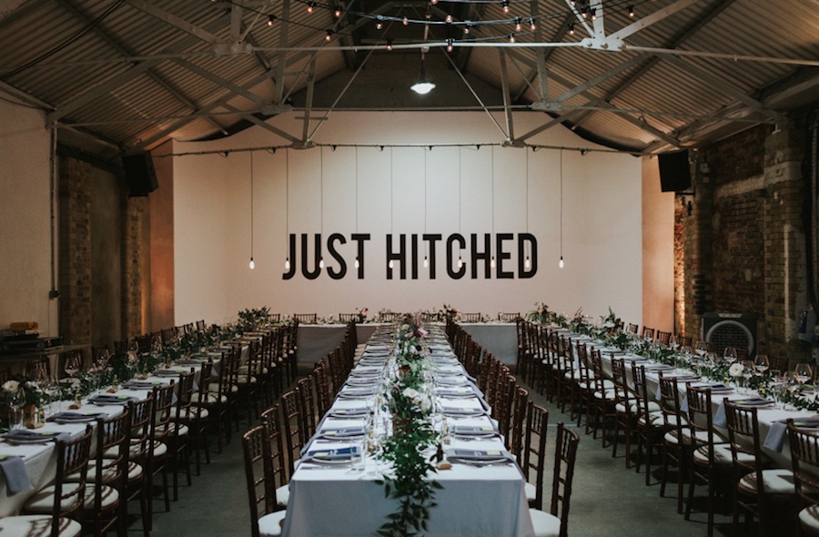 Elegant wedding reception setup in Shoreditch Studios with "JUST HITCHED" sign.