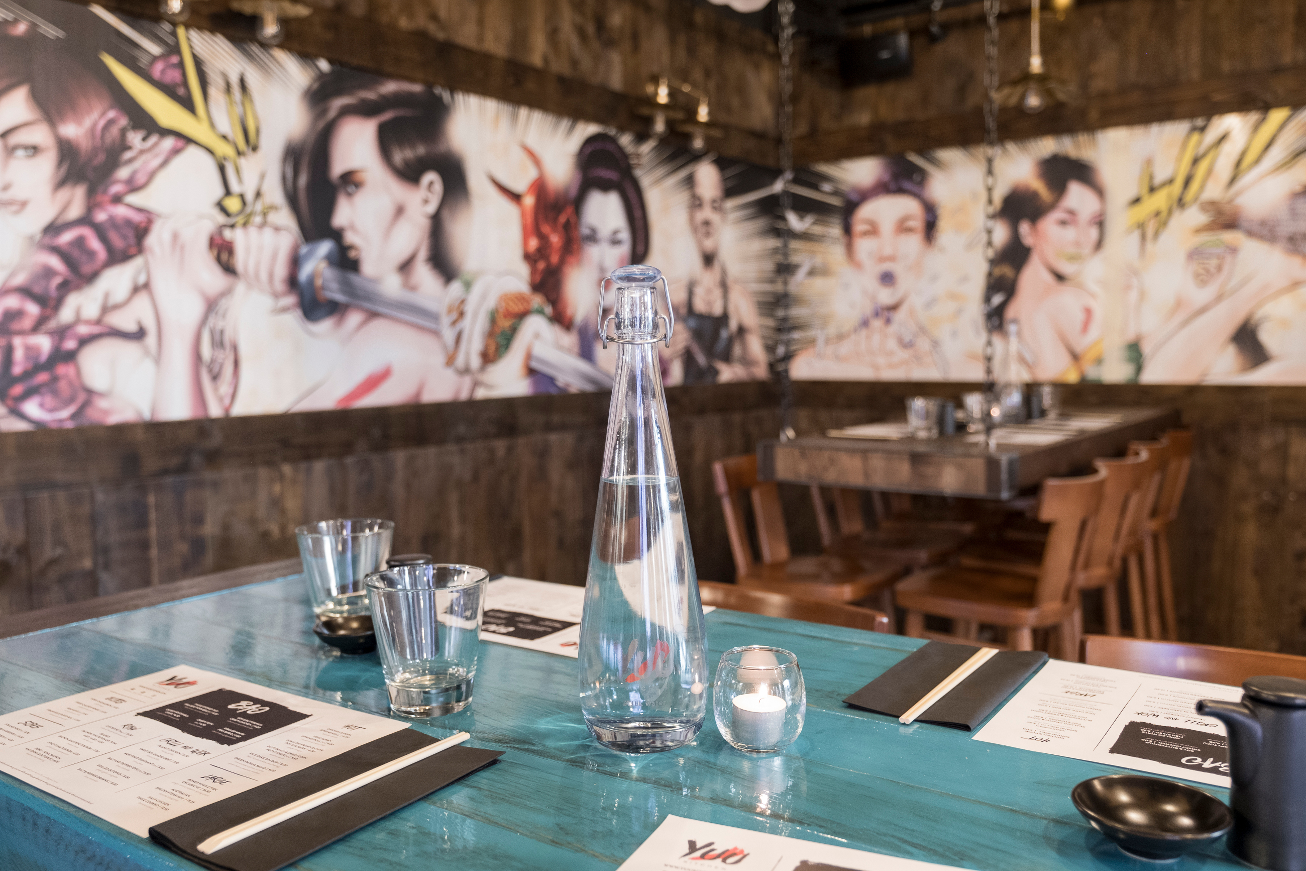 Vibrant dining space at Yuu Kitchen for creative meetings and events with artistic mural.