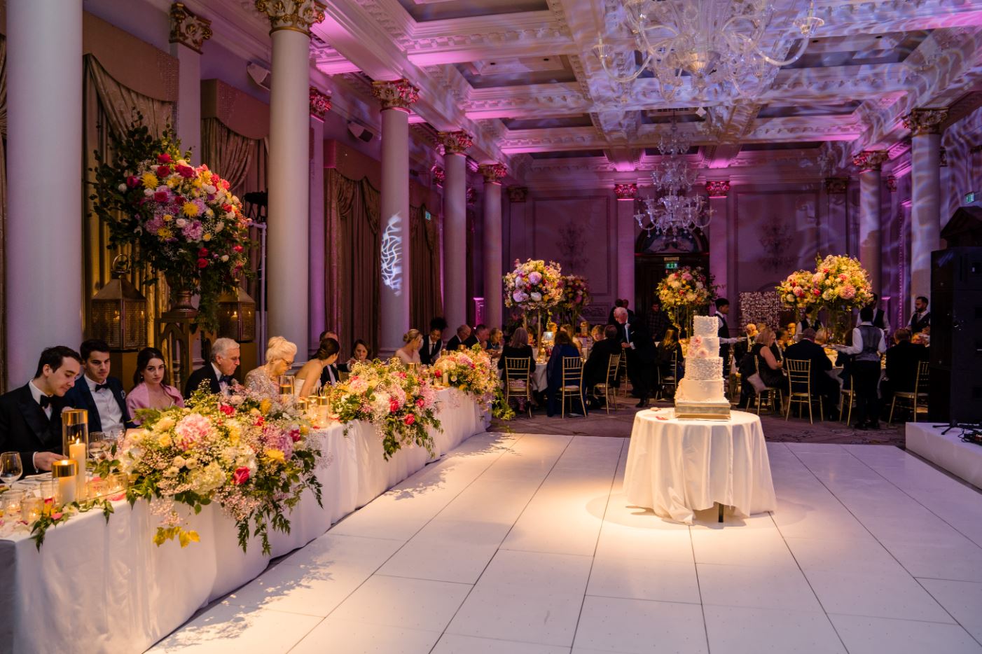 Grand Ballroom at The Langham, London: elegant wedding venue with floral decor and cake display.