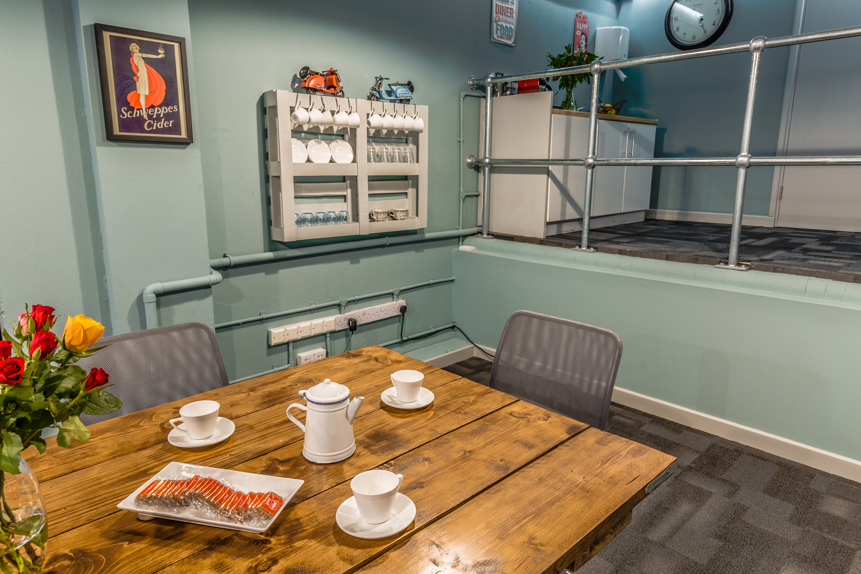 Cozy meeting space at The Loading Dock with wooden table and tea service for team gatherings.