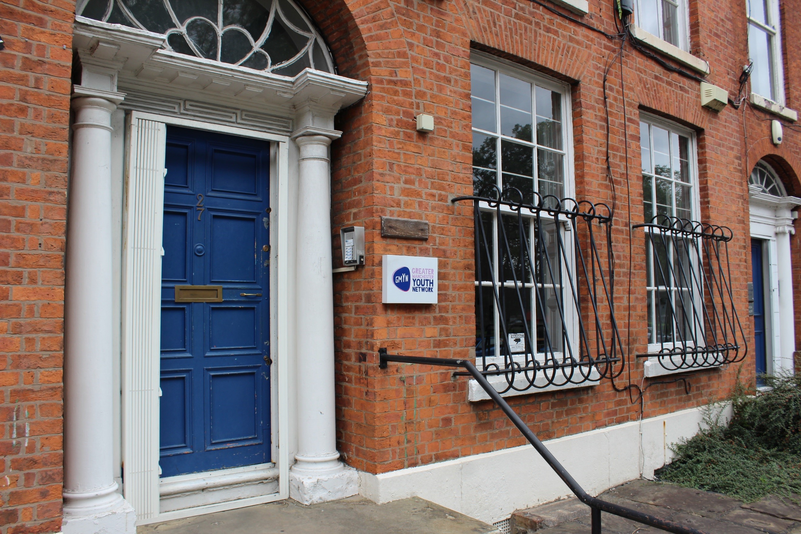 Charming brick building with blue door, ideal for corporate meetings and workshops.