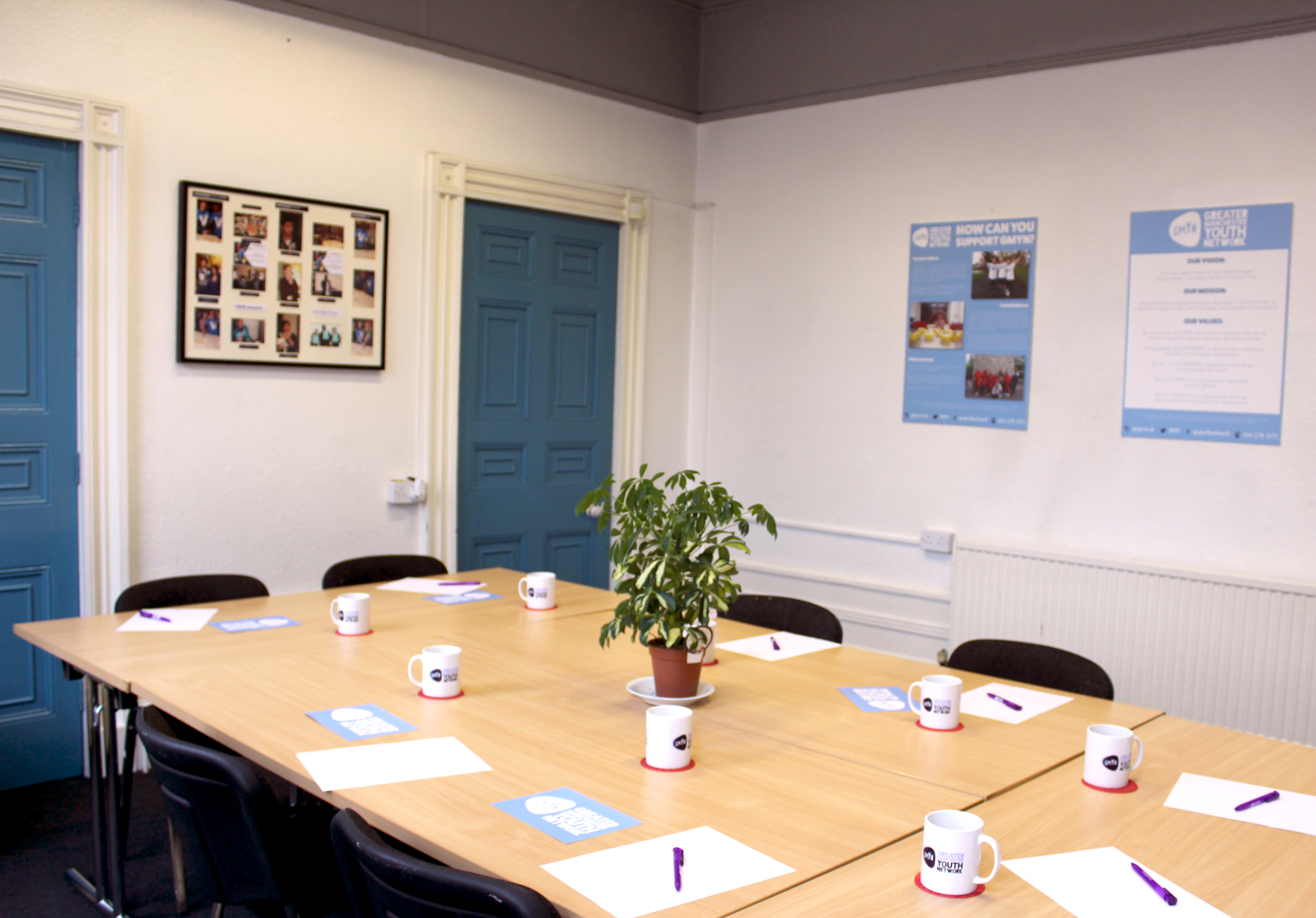 Boardroom in GMYN Offices with branded mugs, ideal for meetings and workshops.