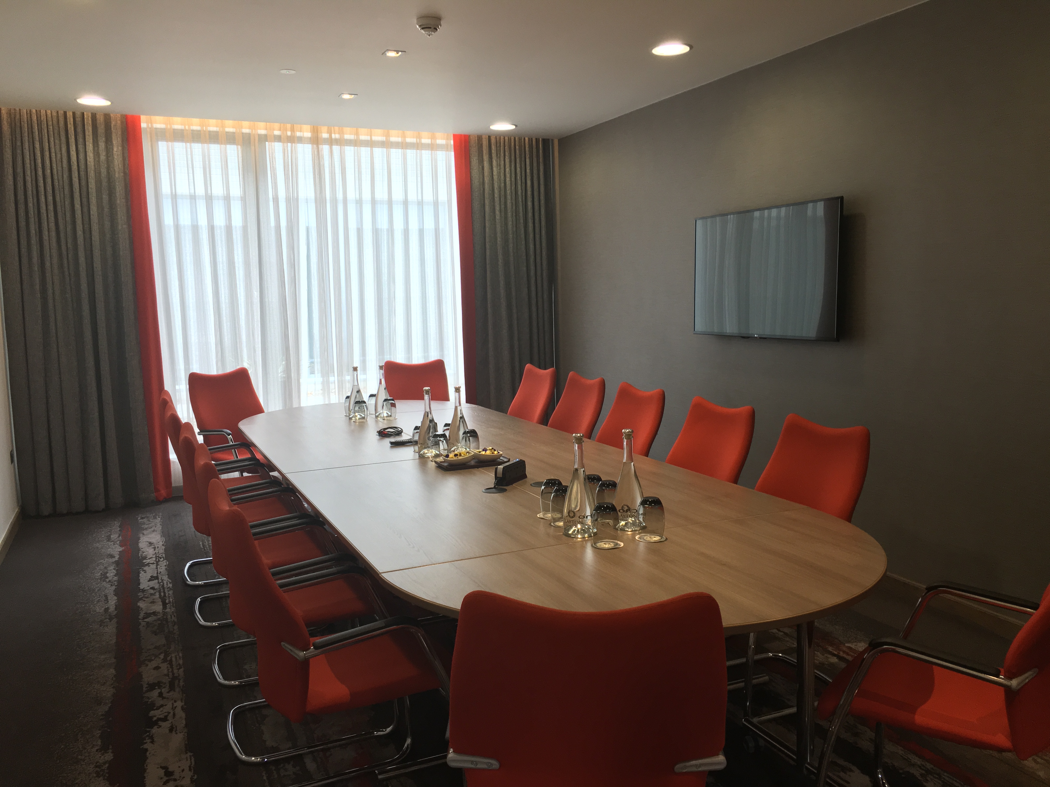 Griffin Suite conference room with wooden table and orange chairs, perfect for meetings.