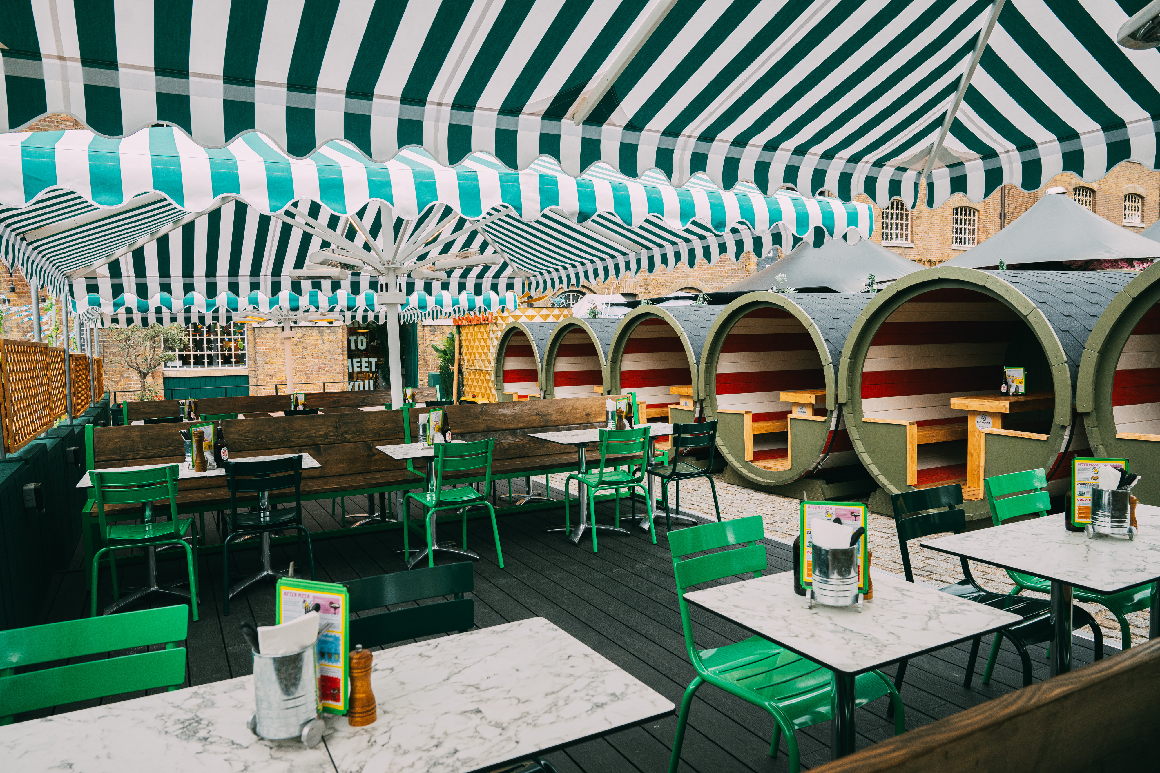 Outdoor event space at The Pizza Playground with striped canopies, ideal for gatherings.
