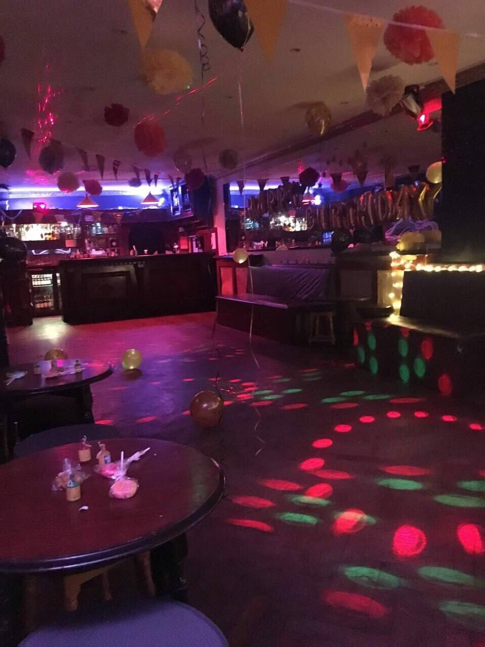Vibrant event space at Moustache Bar Dalston with colorful lighting for celebrations.