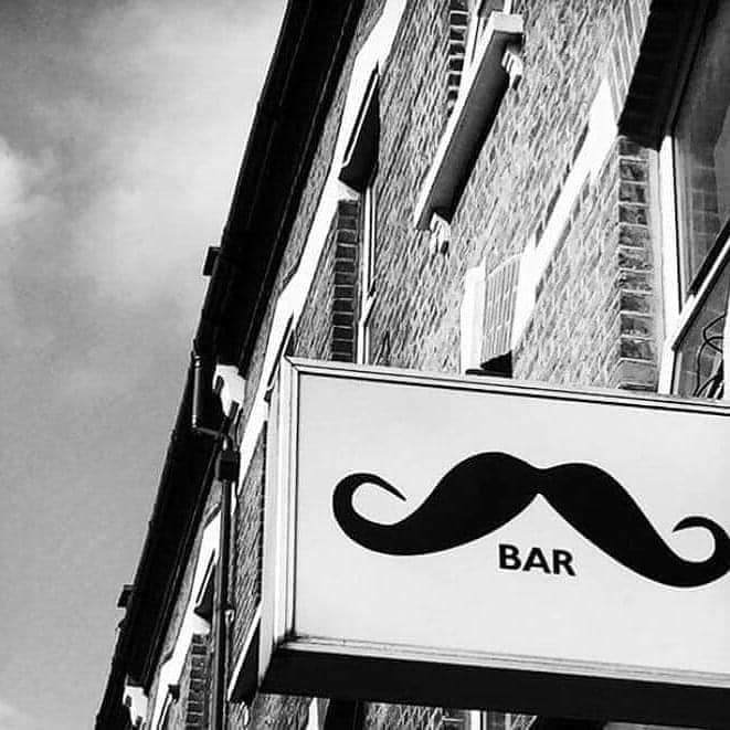 Stylish mustache sign at Moustache Bar Dalston, perfect for networking events.