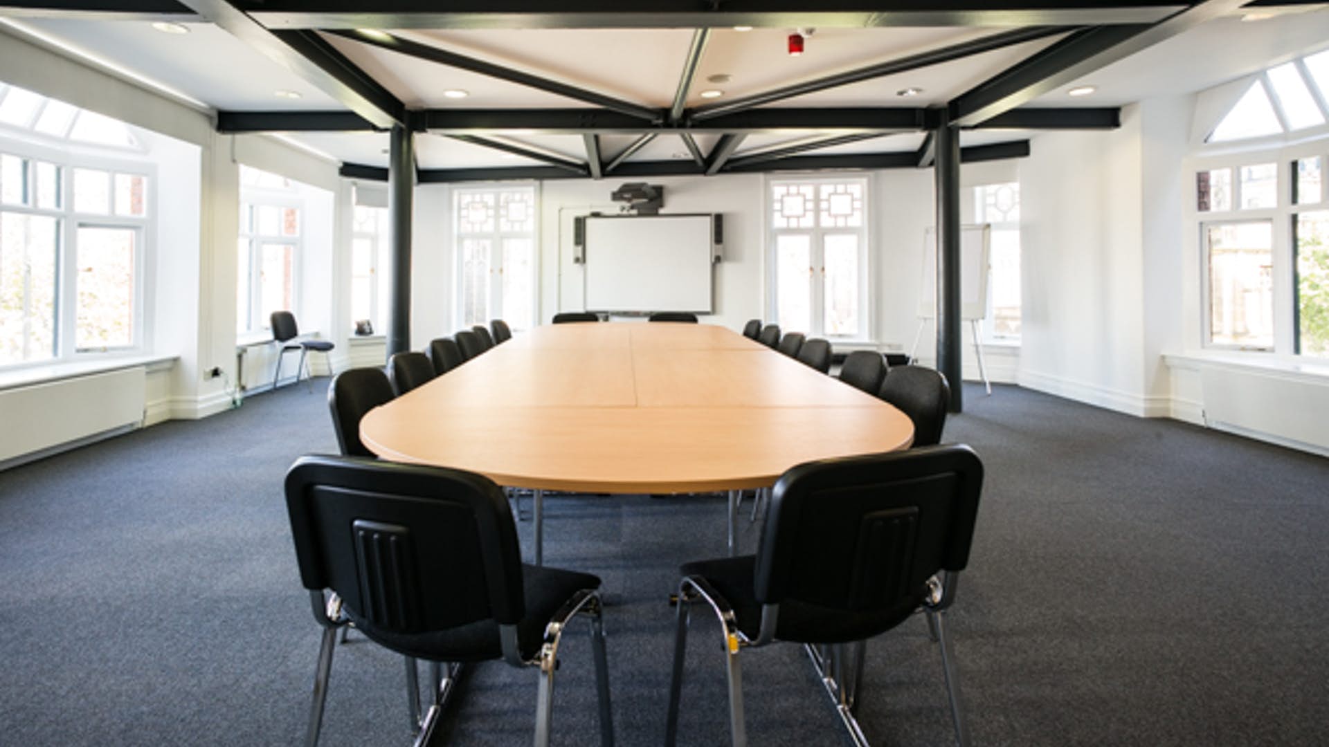 Modern meeting room with oval table, ideal for workshops and strategic planning.