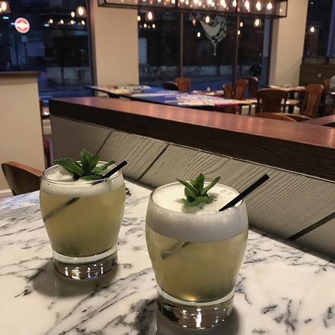 Elegant cocktails on marble table at Assenheims Bar & Grill for networking events.