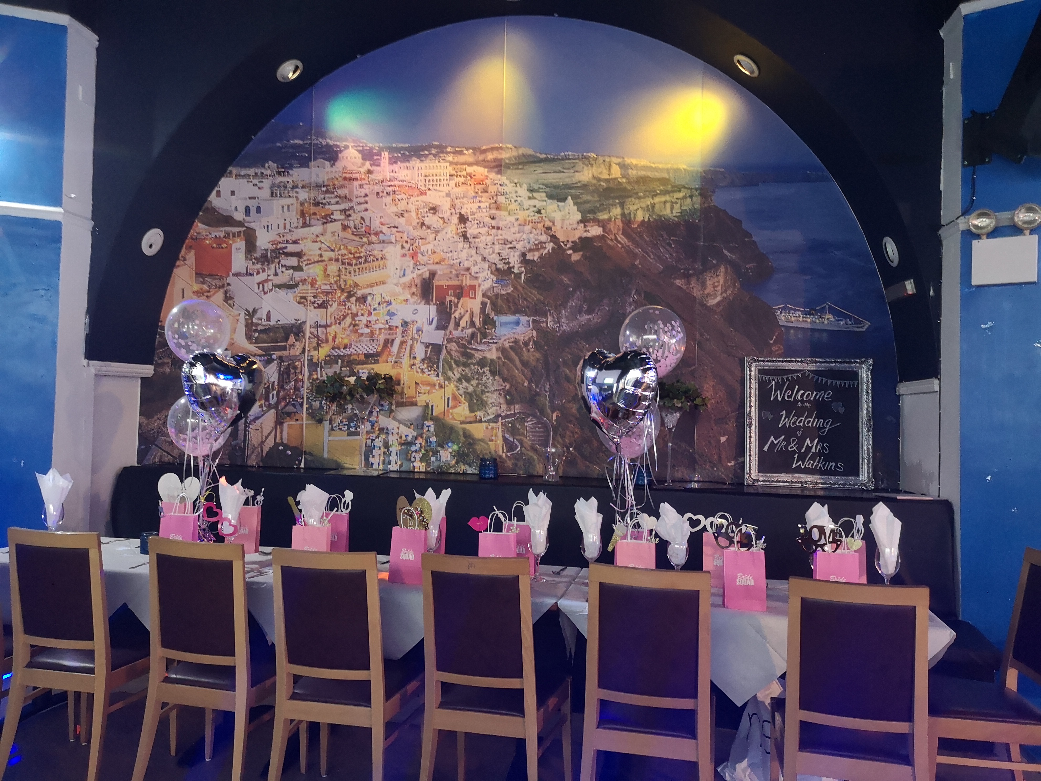 Elegant event table setup with balloons at Santorini Restaurant for celebrations.