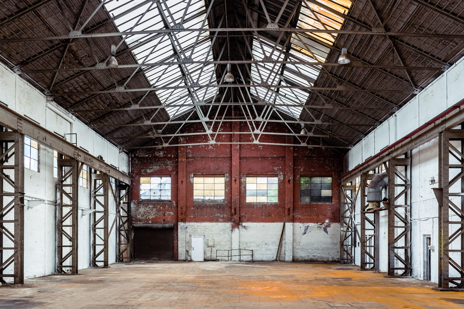 Industrial venue with high ceilings, perfect for corporate events and social gatherings.