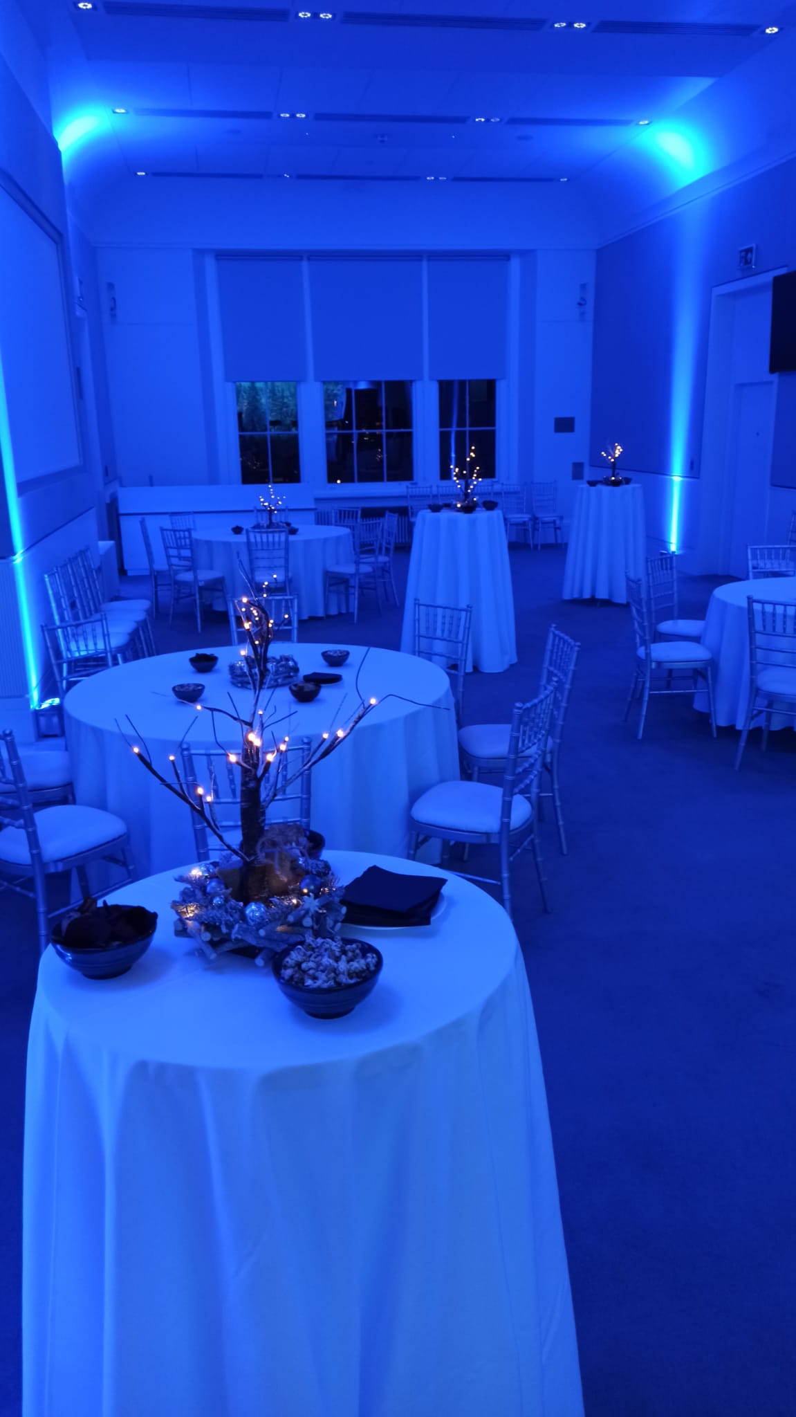 Elegant Christmas party setup with blue lighting and chiavari chairs at Prince Philip House.