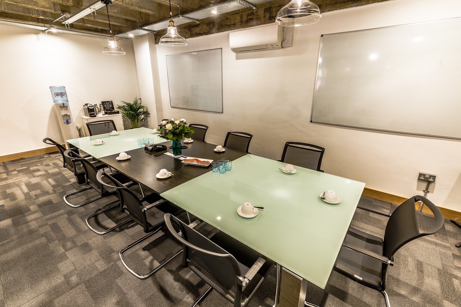 Modern meeting room with glass table, ideal for corporate events and brainstorming sessions.
